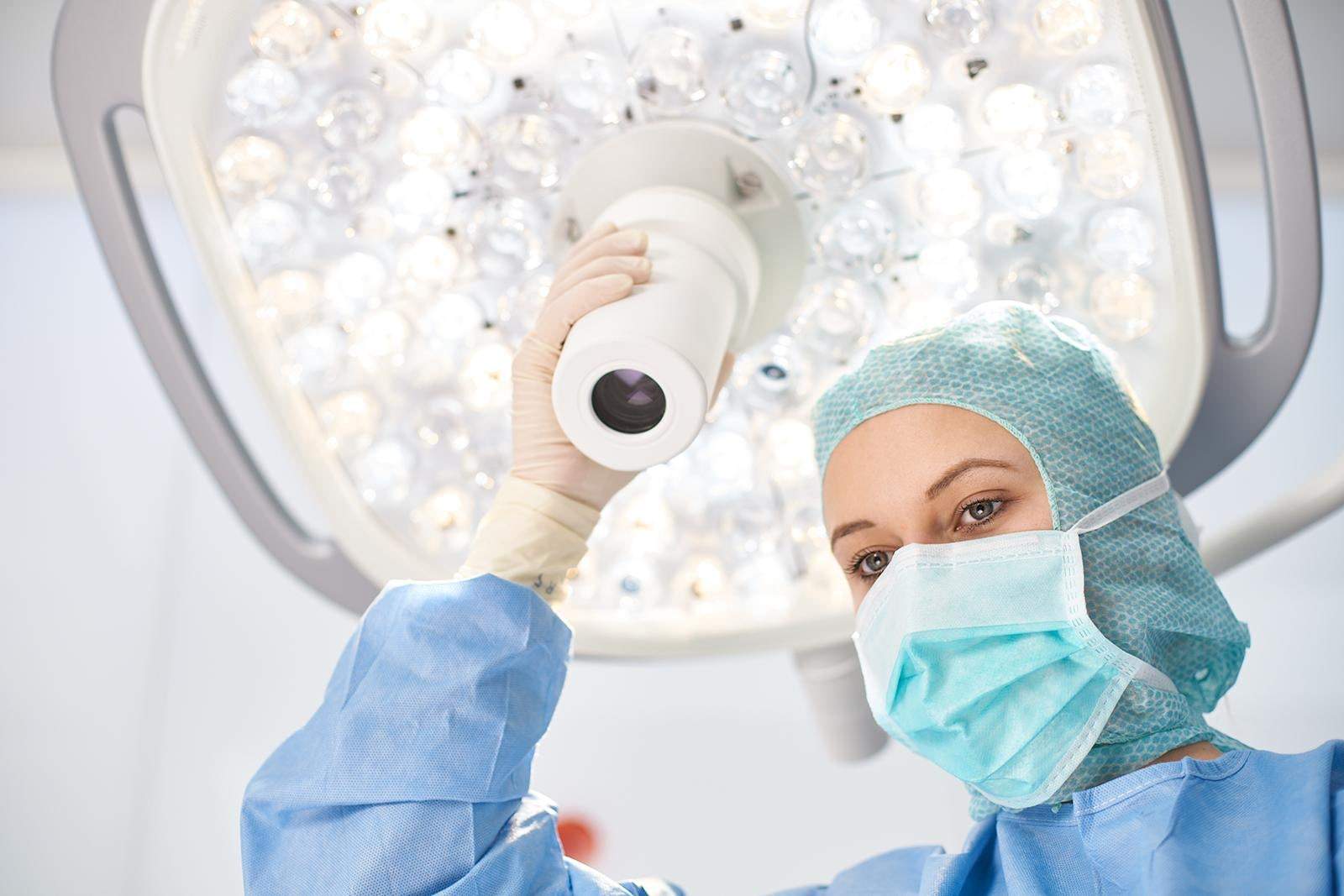 Surgical staff member gripping the handle of the illuminated marLED X in the OR