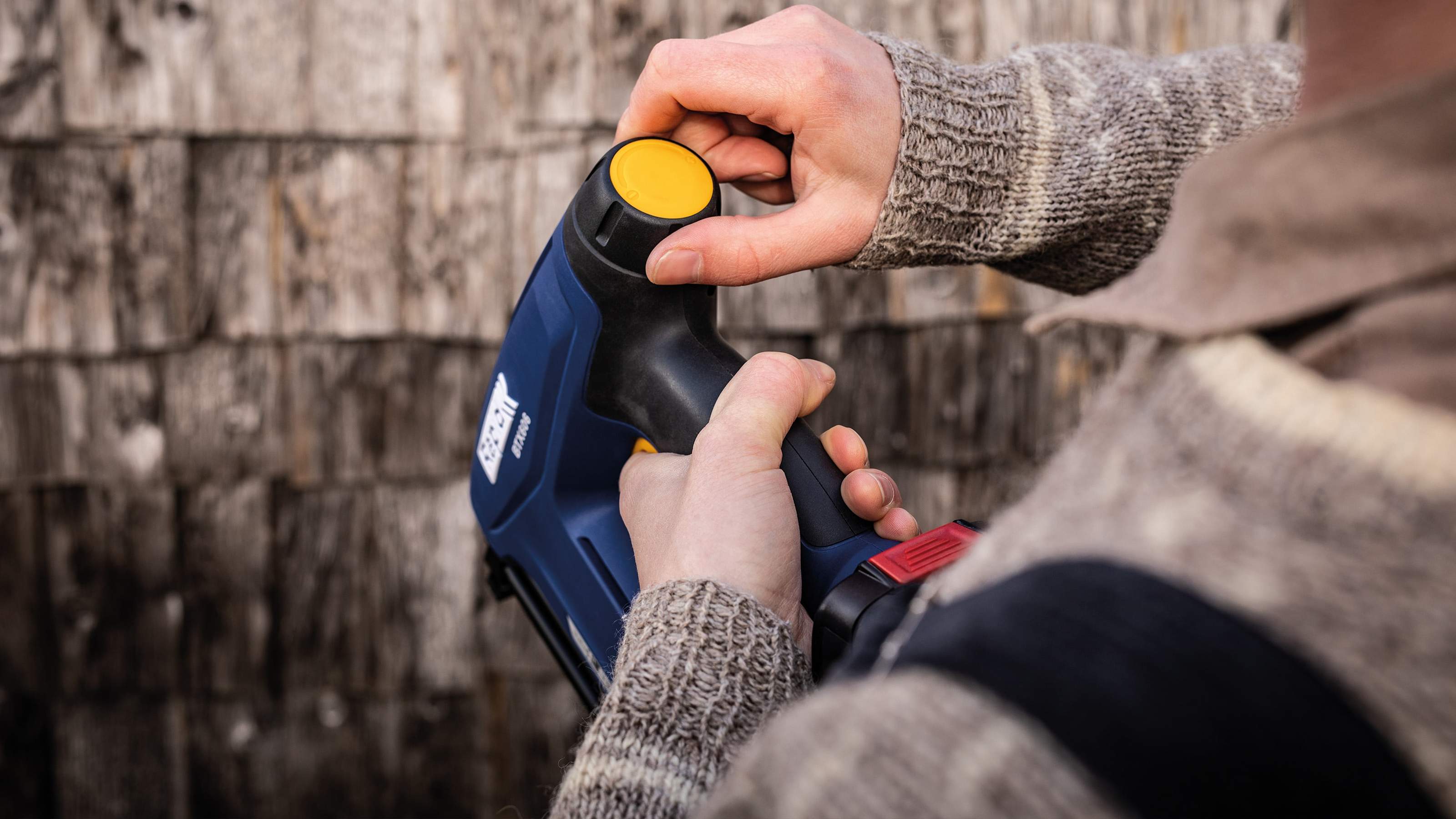Close-up of hands adjusting the trigger switch on a Rapid power tool