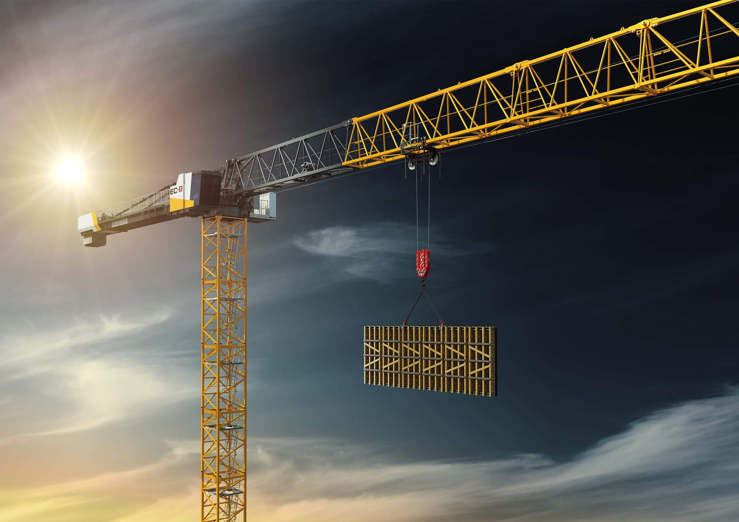 Liebherr-Turmdrehkran der EC-B-Baureihe hebt ein Schalungselement vor Abendhimmel